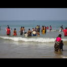 Frauen gehen mit ihren Saris ins Wasser